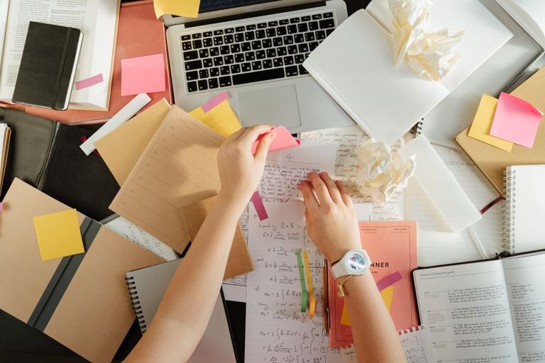 Workspace with books, laptop and notes for application planning